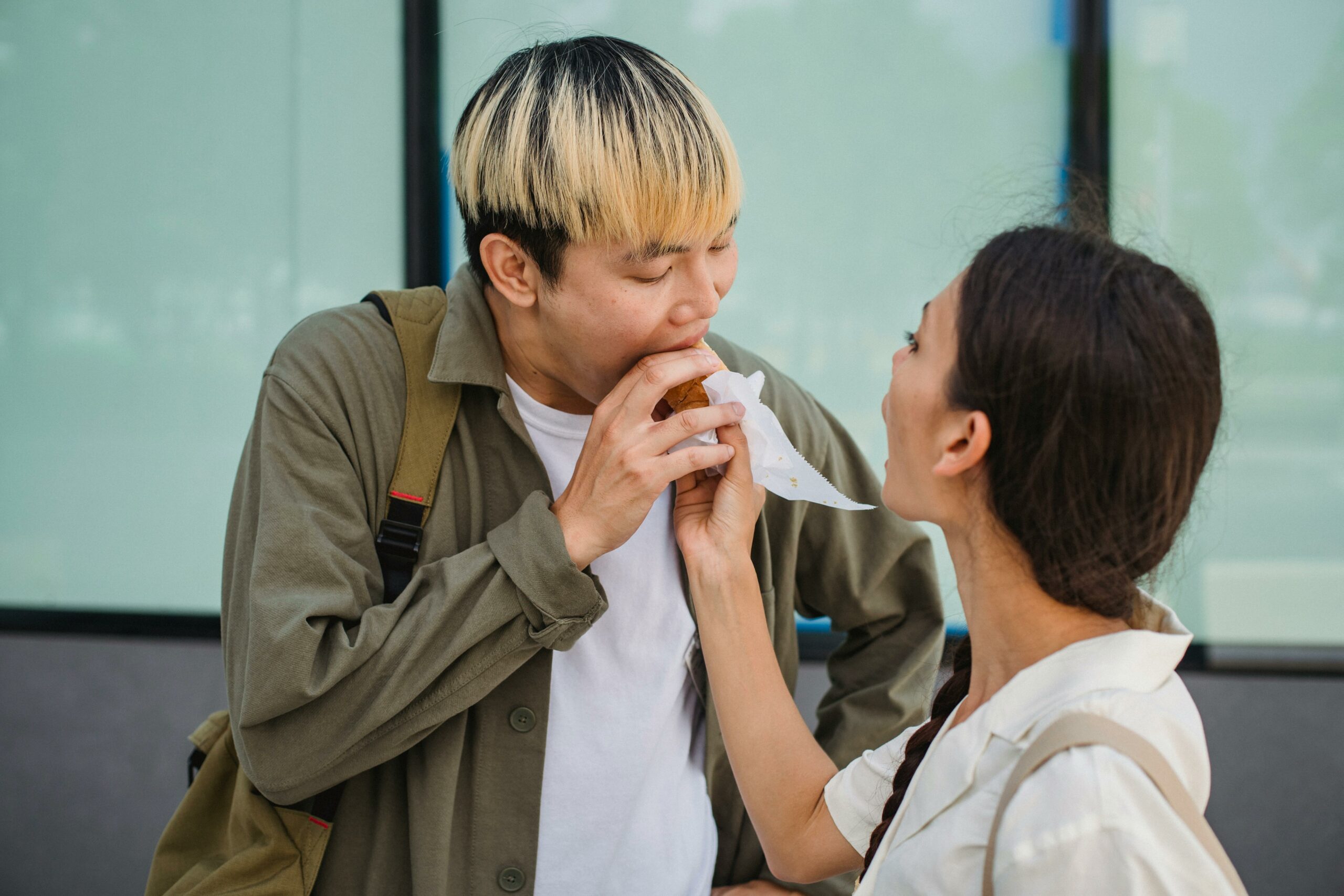 Asiatische Frau, Die Freund Mit Hot Dog Hand Füttert